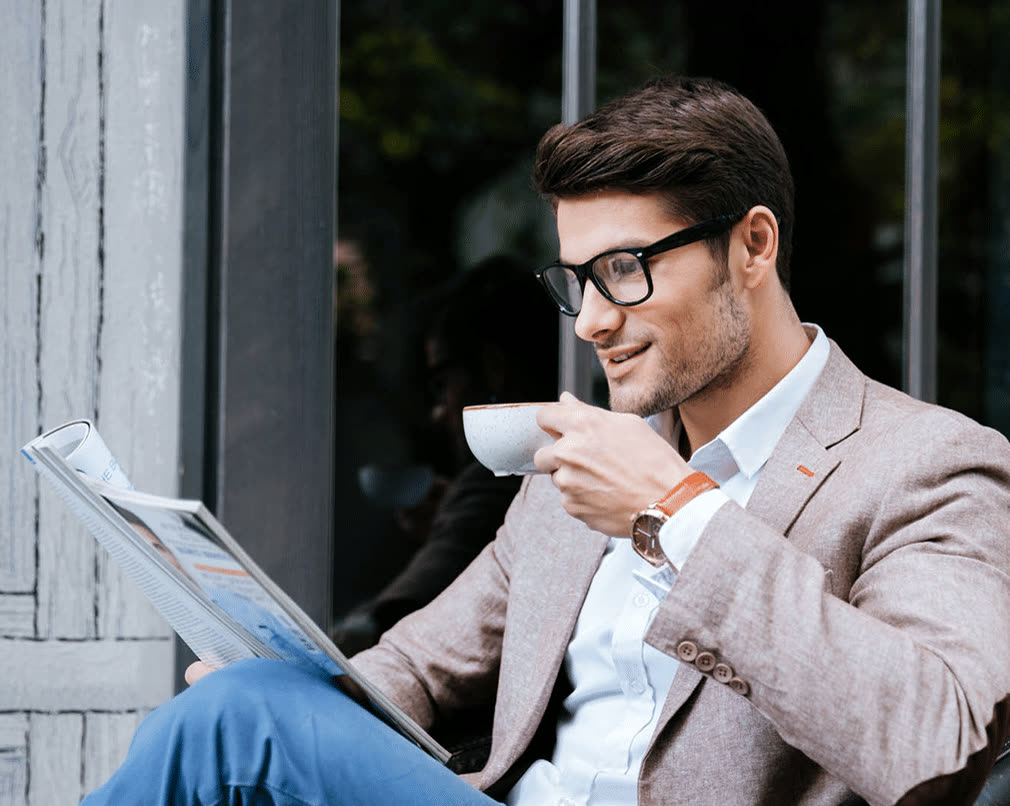 Entspannter Mitarbeiter mit Kaffee und Zeitung